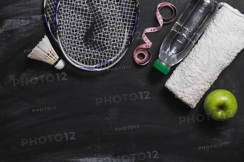Composition with badminton racket water bottle apple