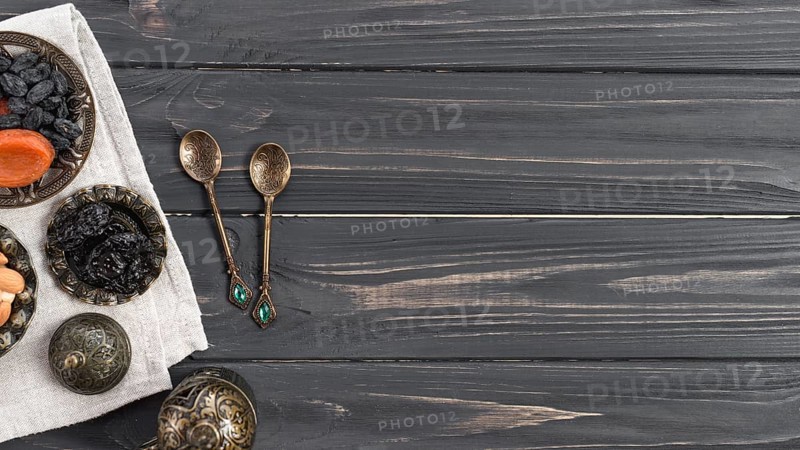 Turkish metallic spoons with dried dates raisin wooden desk