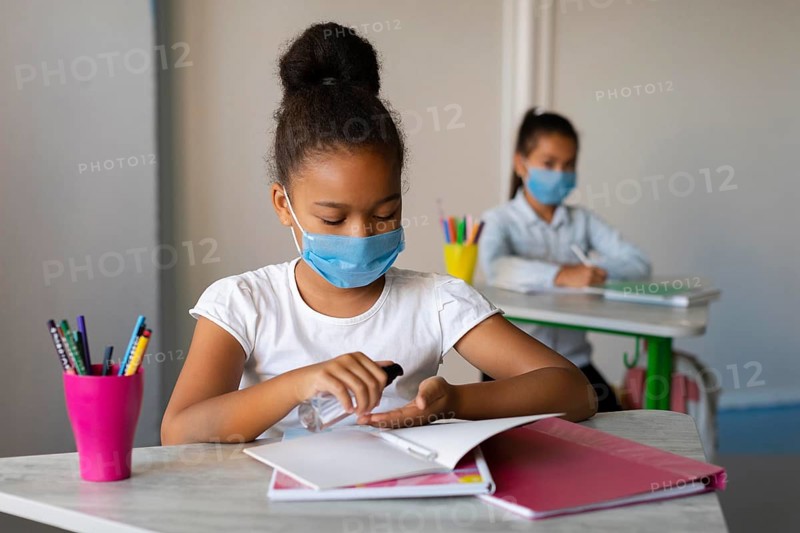 Little girl disinfecting her hands class