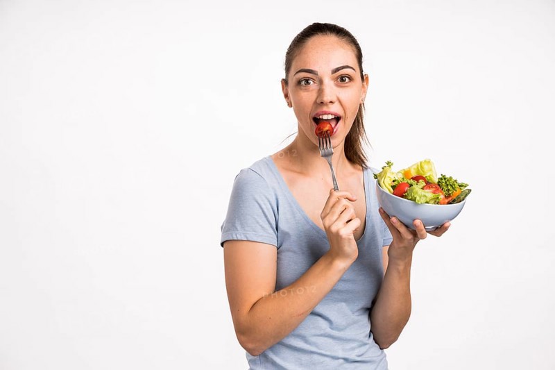 Woman eating tomato with fork