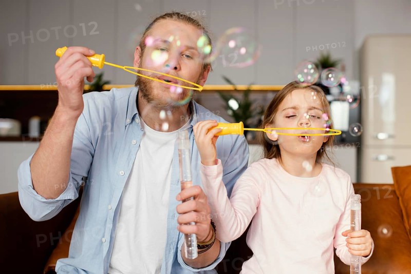 Front view father daughter playing with soap bubbles