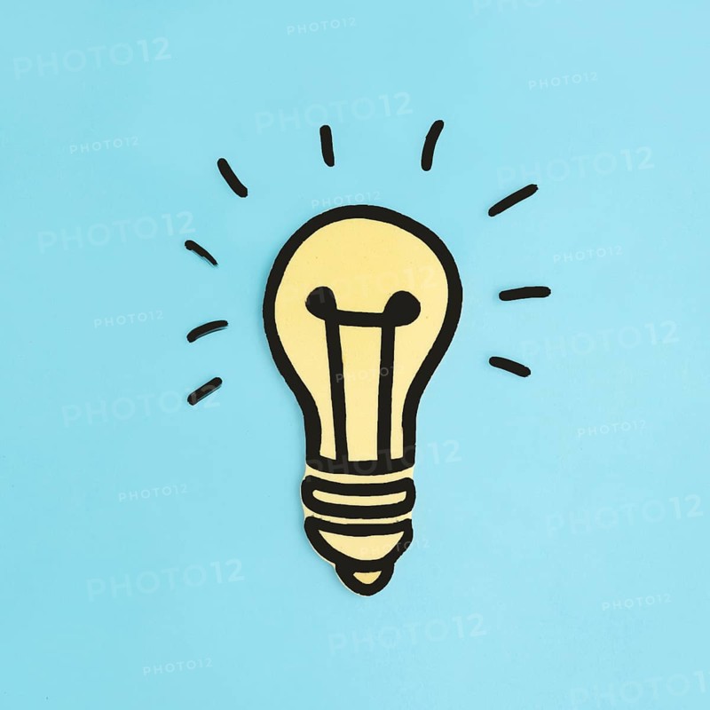 Illuminated paper cutout yellow light bulb blue background