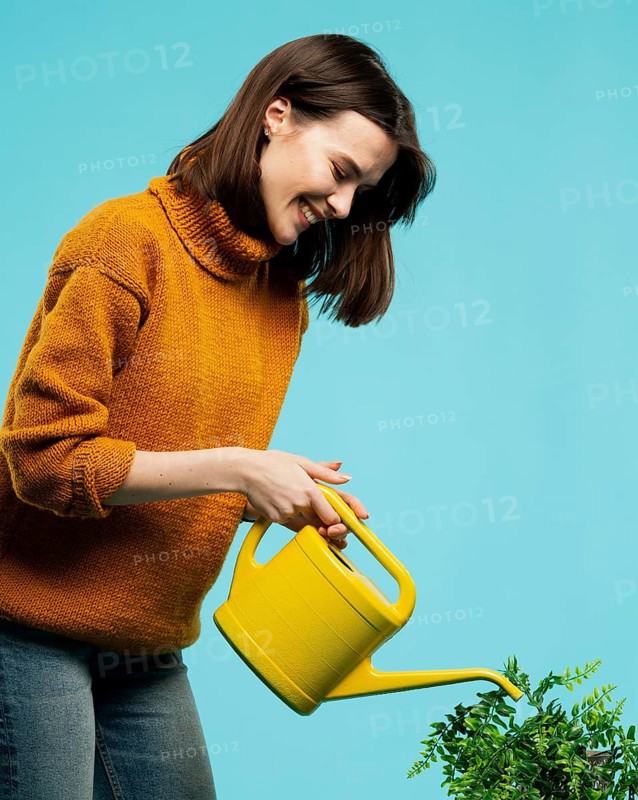 Medium shot woman with watering can