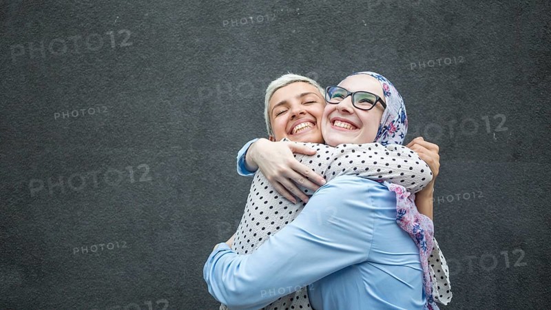 Friends sharing hug with black background
