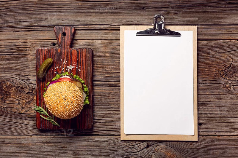 Flat lay burger with mock up clipboard