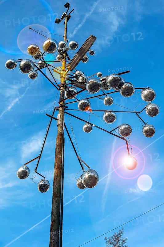 Pole of a street light as a work of art with disco balls