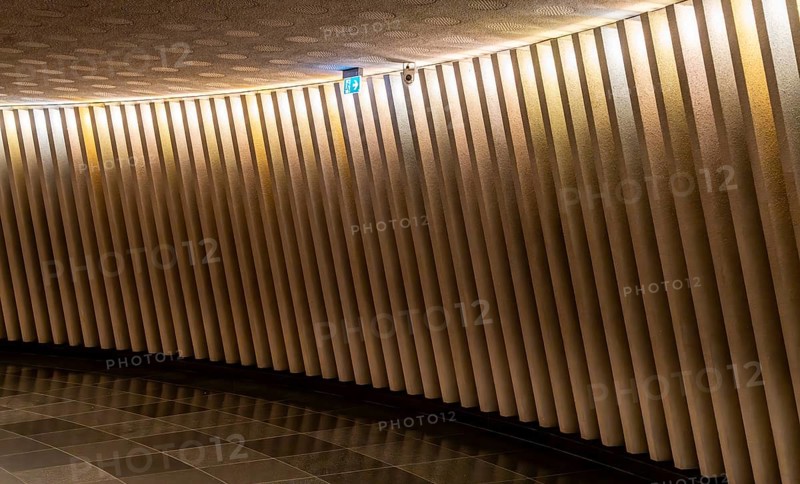 Corridor with concrete wall and a sign indicating the emergency exit