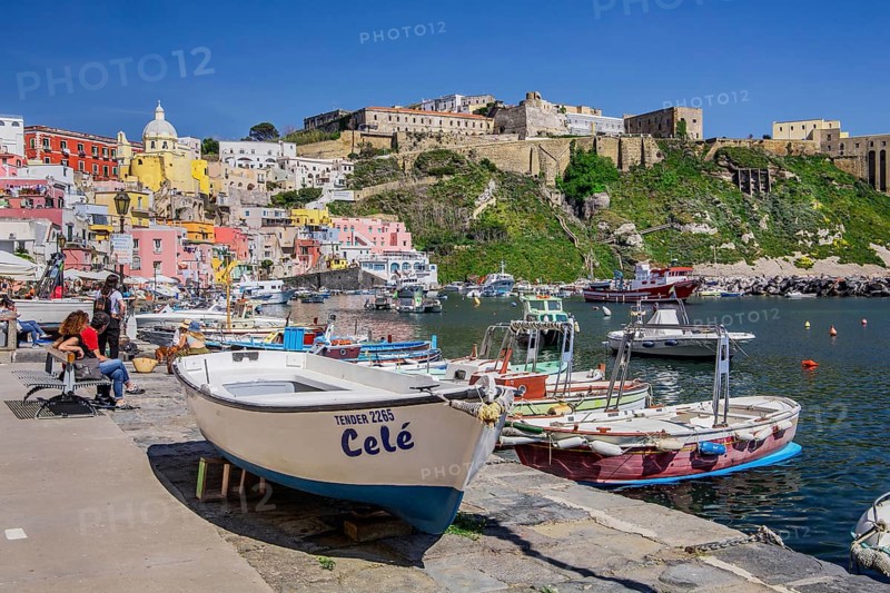 Shore path with fishing boats and fishing harbour of the fishing village Corricella and the fortress Terra Murata