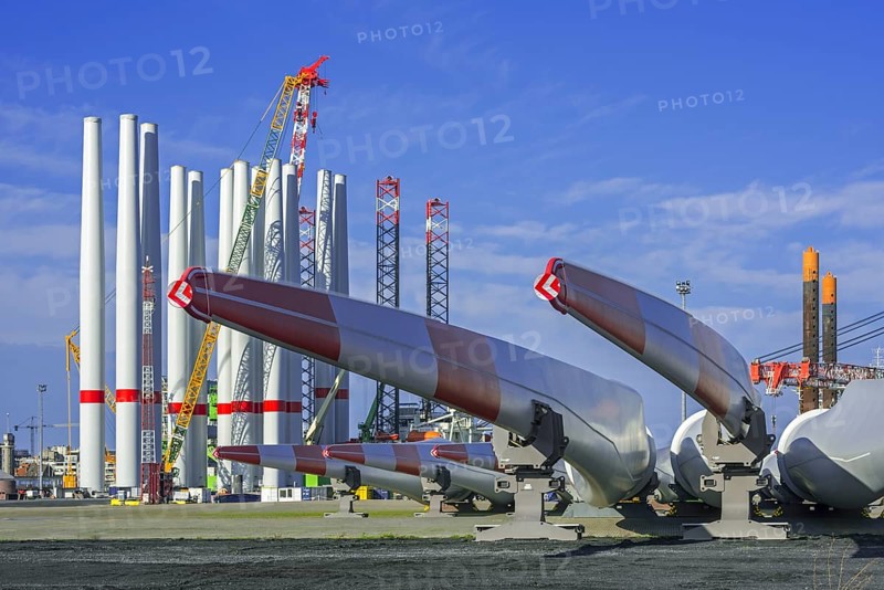 Wind turbine parts like huge rotor blades and steel tower sections for assembling wind turbines at REBO heavy load terminal in Ostend port