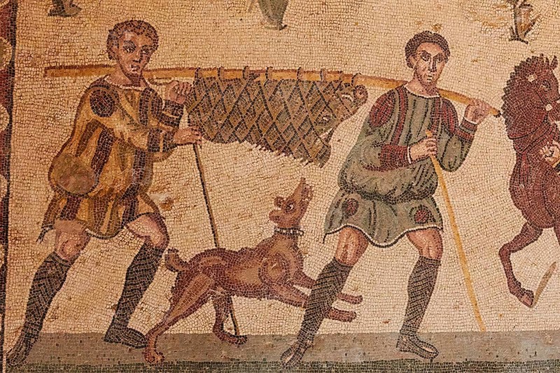 Hunter with prey animal on poles