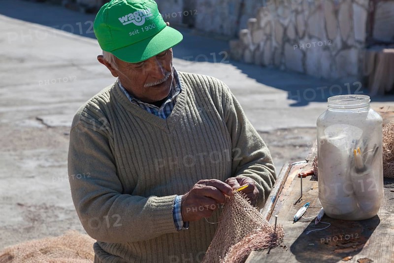 Fishermen mending nets in the Old Port of Antalya