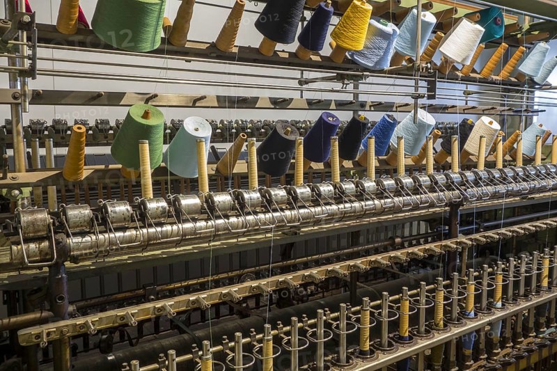 Colourful bobbins with yarns on twisting frame in cotton mill