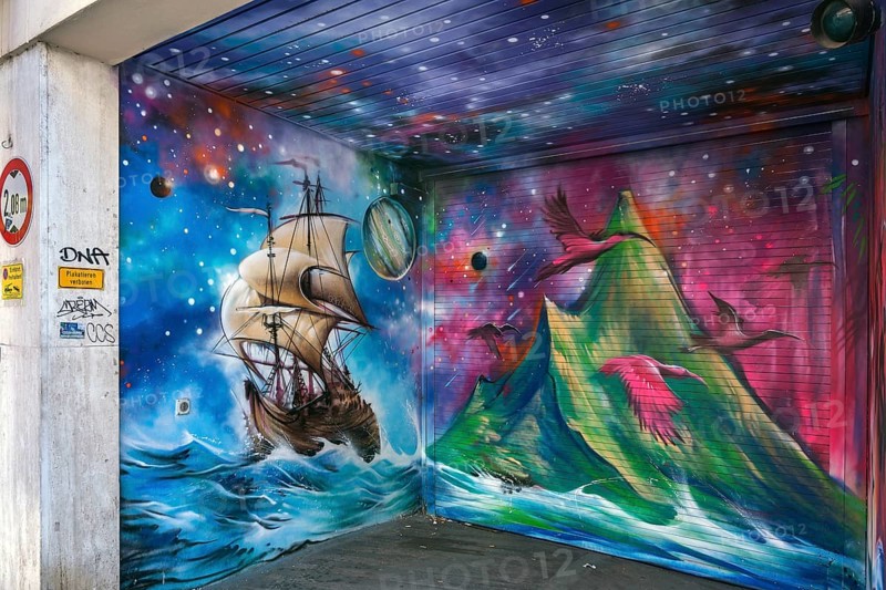 Graffiti with antique sailing ship and volcano on garage entrance
