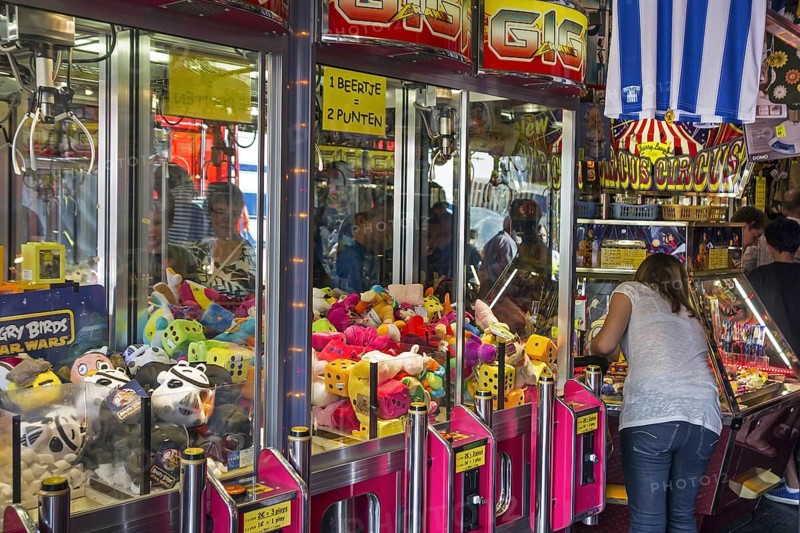 Arcade with claw crane game machines filled with toys and coin pusher