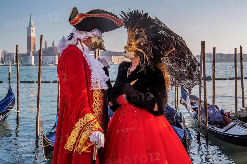 Carnival masks on the waterfront with San Giorgio Island at the time of Carnival