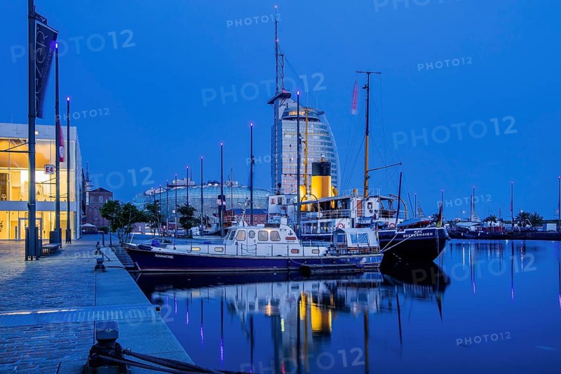 Historic ships in the New Harbour with the Atlantic Sail City Hotel at dusk