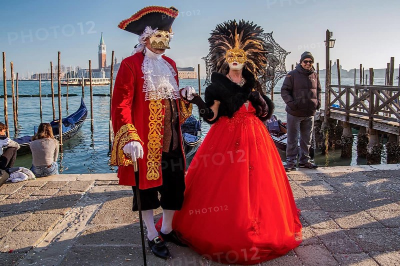 Carnival masks on the waterfront with San Giorgio Island at the time of Carnival