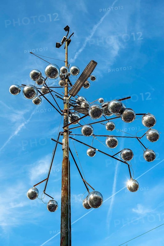 Pole of a street light as a work of art with disco balls