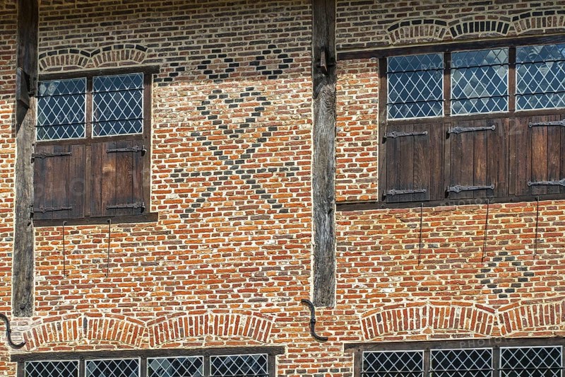 Flemish mason's symbols in brickwork on facade of 16th century brick house showing checks