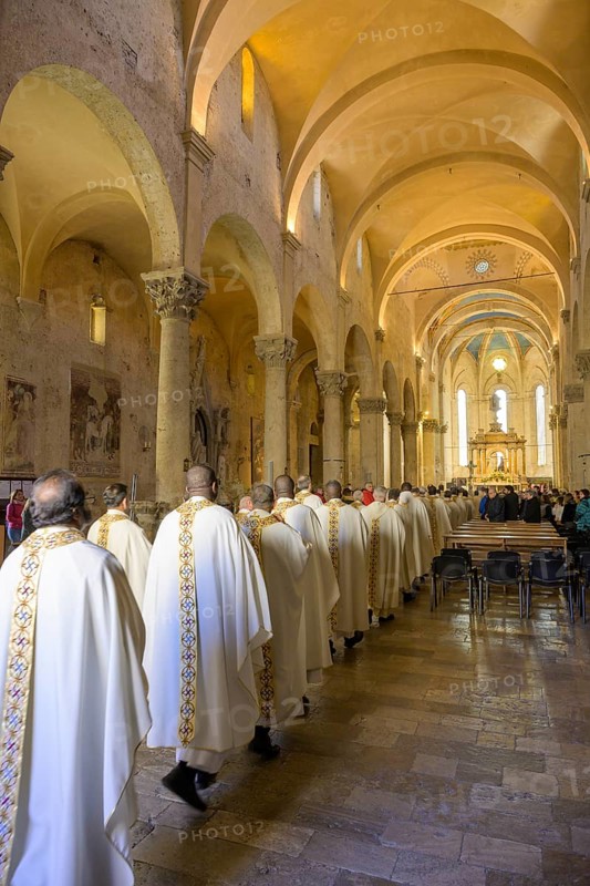 Priests in solemn vestments enter the Cathedral di San Cerbone for Mass on Holy Thursday