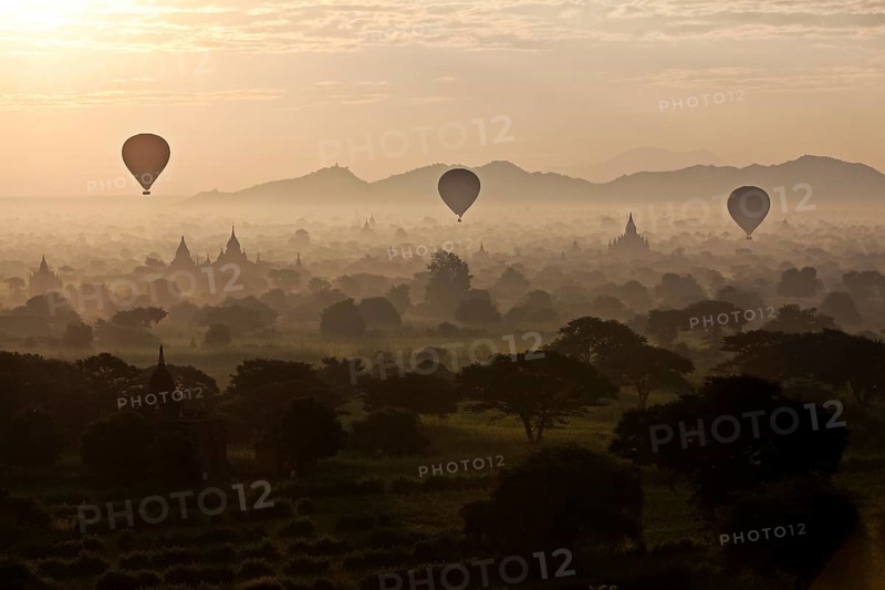 Hot air balloons over landscape with stupas