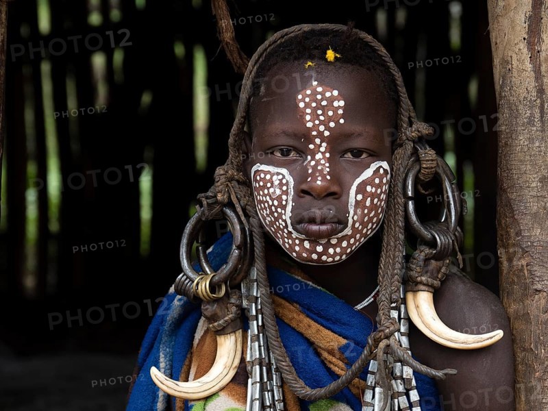 Boy of the Mursi tribe with headdress and face painting