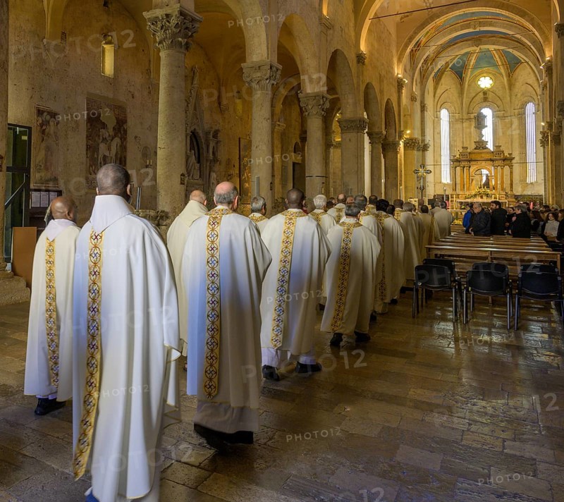 Priests in solemn vestments enter the Cathedral di San Cerbone for Mass on Holy Thursday