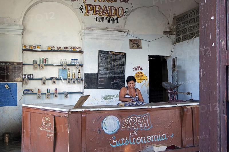 Shopkeeper behind counter of Cuban state shop in Cienfuegos