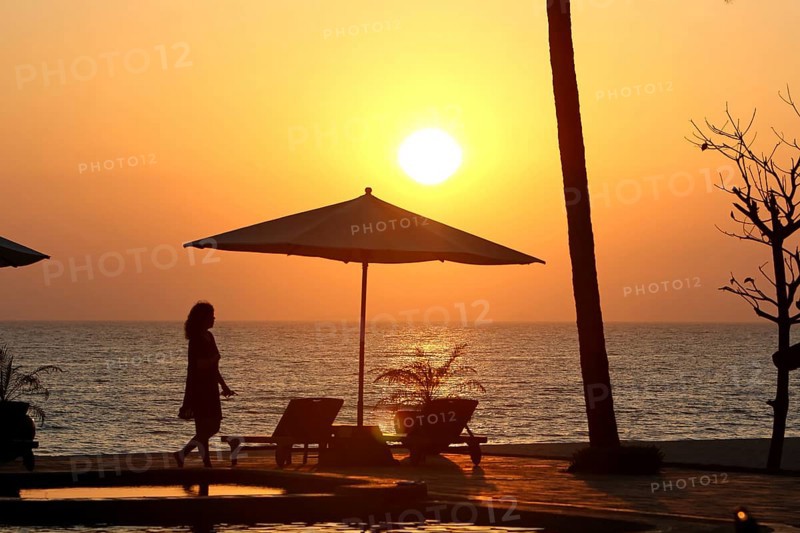 Parasol and woman in evening sun
