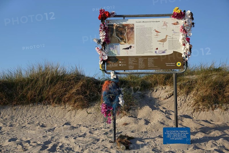 Tourist information board decorated with marine litter on the island of Minsener Oog