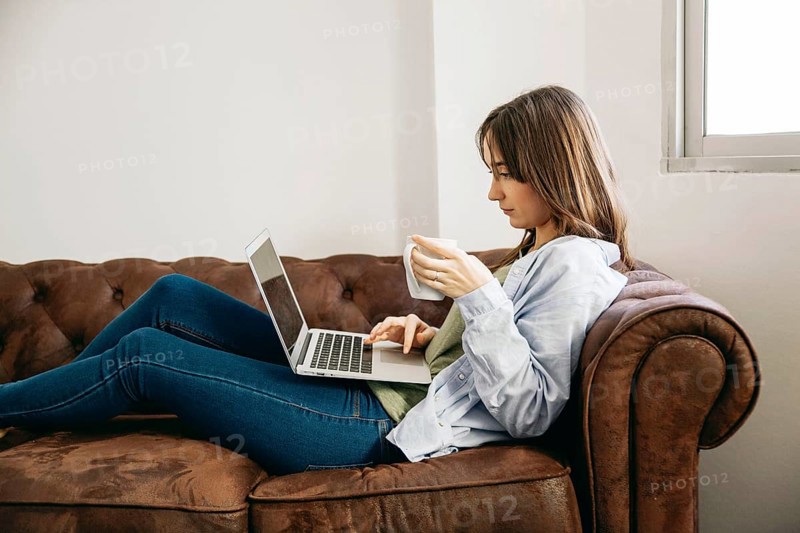 Woman lounging with coffee laptop