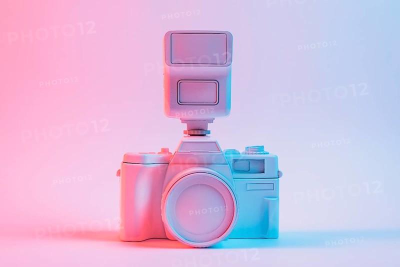 Blue light vintage painted pink camera against pink backdrop