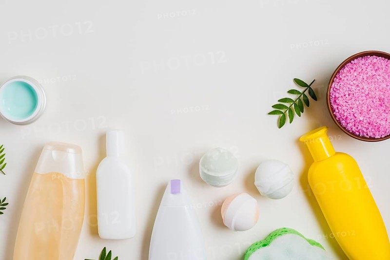 Cosmetic products with bath bomb pink salt cream white backdrop