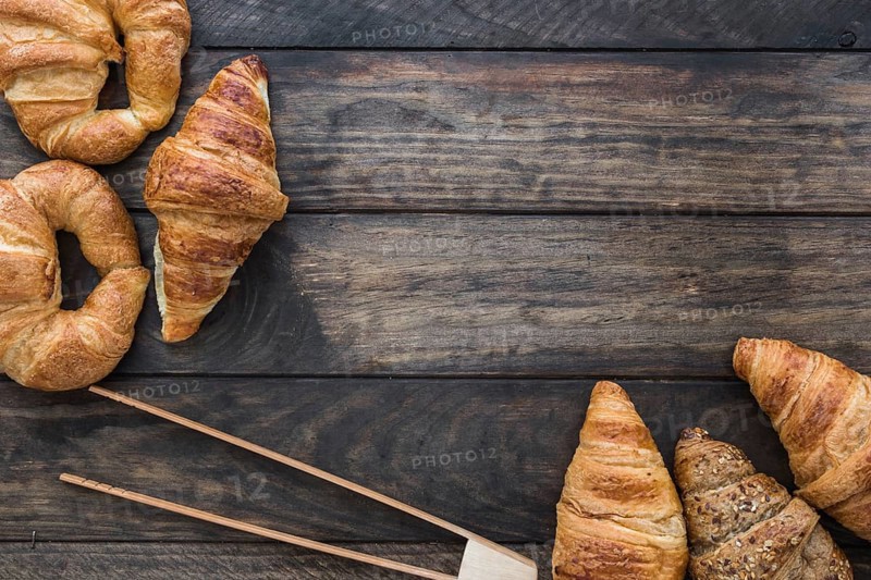 Wooden tongs near croissants