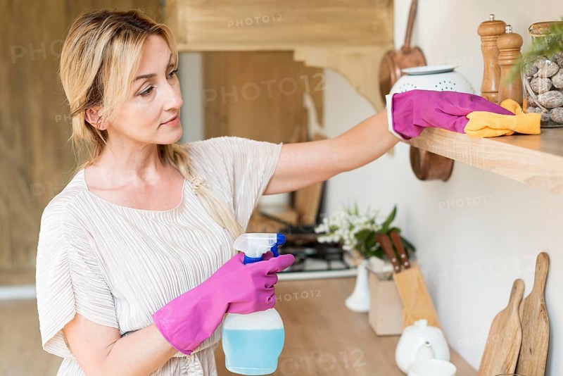 Young mother cleaning shelves house