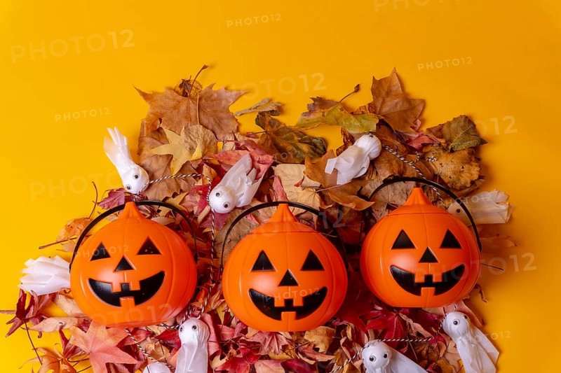 Overhead view of orange Halloween pumpkins on a background of yellow