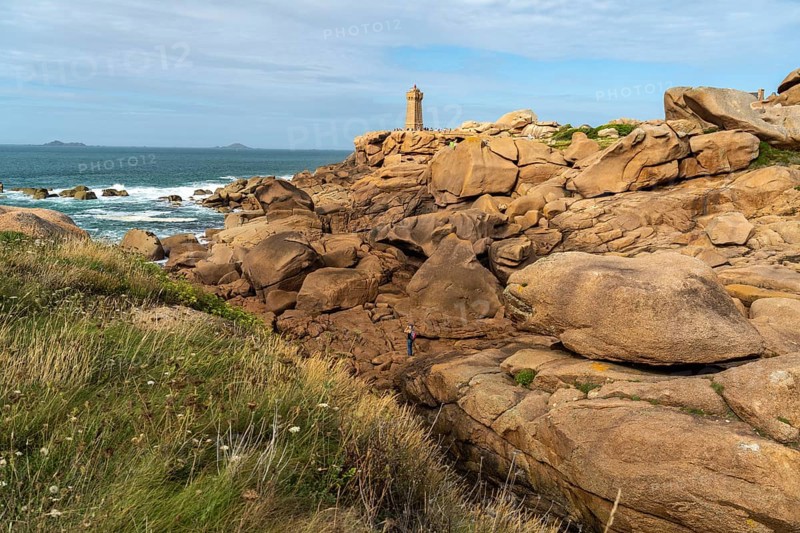 The rocks of the pink granite coast Cote de Granit Rose and the lighthouse Phare de Ploumanac'h near Ploumanac'h