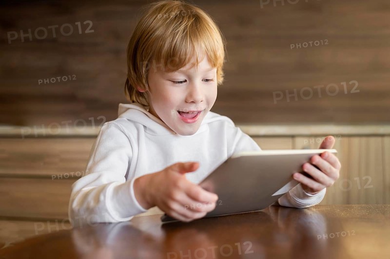 Front view young boy using tablet table