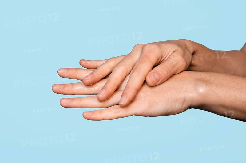 Sideways woman washing hands isolated blue