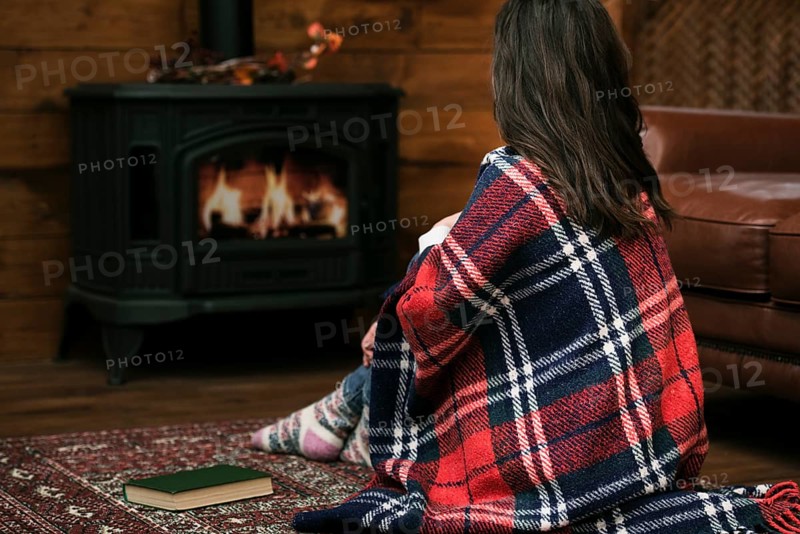 Woman covered blanket fireplace