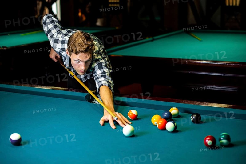 Medium shot guy with pool cue billiard table