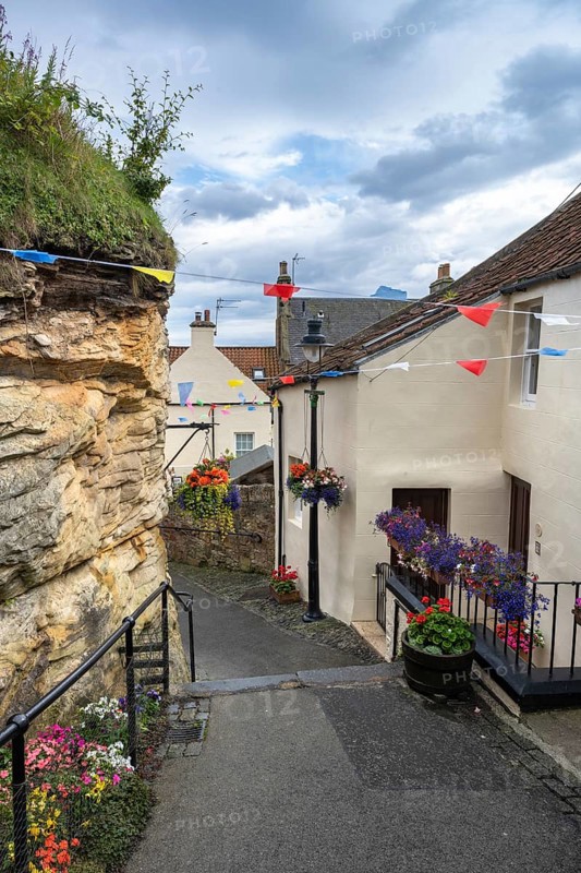 Alley decorated with flowers and colourful flags in the fishing village of Pittenweem