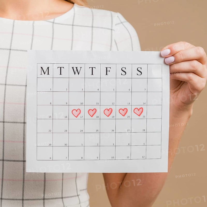 Close up period calendar with drawn heart shapes