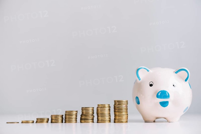 Piggybank increasing stacked coins reflective desk