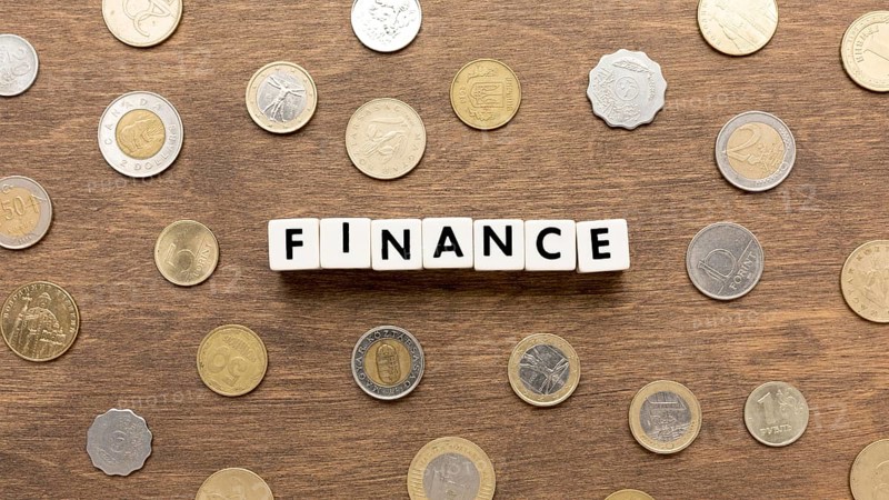 Finance word written scrabble letters coins