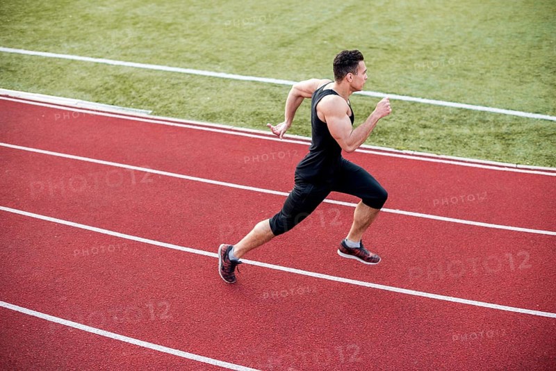 Male athlete arrives finish line racetrack during training session