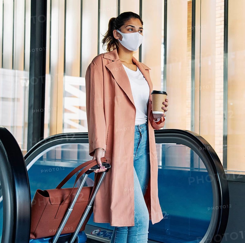 Woman with luggage medical mask airport during pandemic