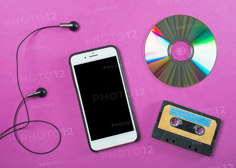 Earphone cellphone compact disc cassette tape purple background