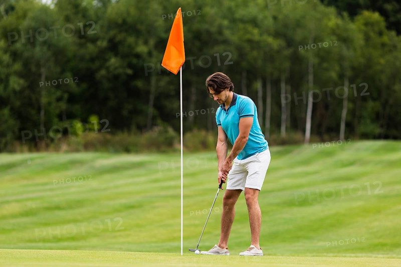 Full shot fit adult man playing golf