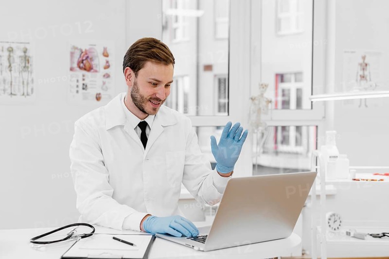 Medium shot doctor working laptop